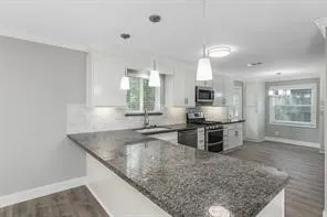 a kitchen with stainless steel appliances granite countertop a sink stove and refrigerator