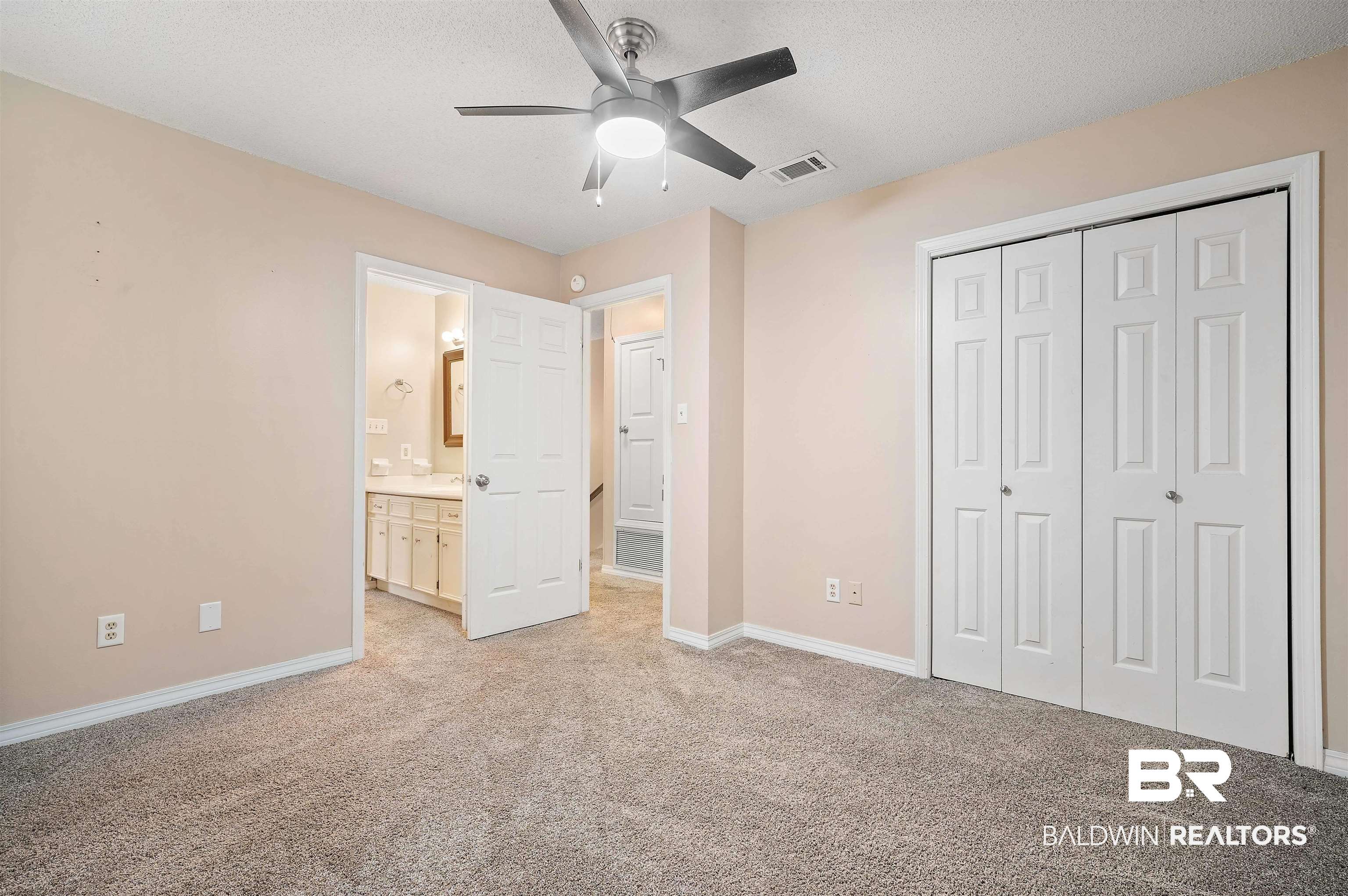 804 Wildwood Avenue Mobile, AL 36609 - Photo 22 of 30 Unfurnished bedroom featuring a textured ceiling, a closet, light carpet, connected bathroom, and ceiling fan