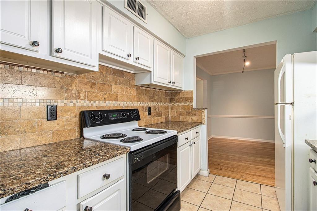 5143 Roswell Road, Unit 8 Atlanta, GA 30342 - Photo 14 of 27 a kitchen with granite countertop a sink stove and cabinets