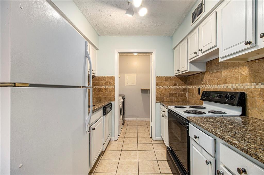 5143 Roswell Road, Unit 8 Atlanta, GA 30342 - Photo 15 of 27 a kitchen with stainless steel appliances granite countertop a refrigerator a stove and a sink
