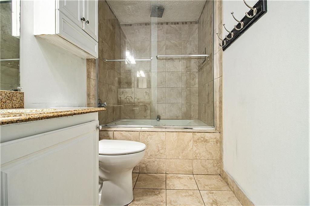 5143 Roswell Road, Unit 8 Atlanta, GA 30342 - Photo 25 of 27 a bathroom with a granite countertop sink toilet and shower