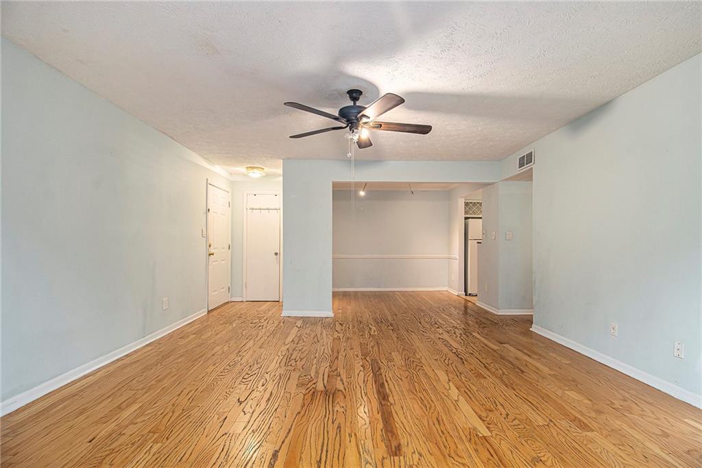 5143 Roswell Road, Unit 8 Atlanta, GA 30342 - Photo 6 of 27 a view of empty room with wooden floor and fan