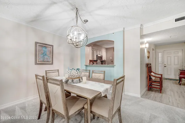 a view of a dining room with furniture and chandelier