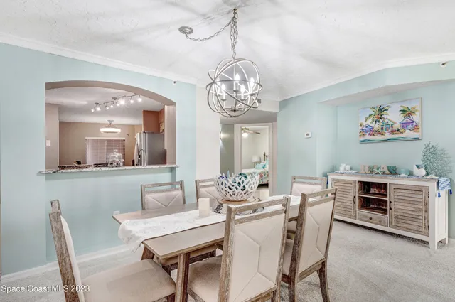 a view of a dining room with furniture and chandelier