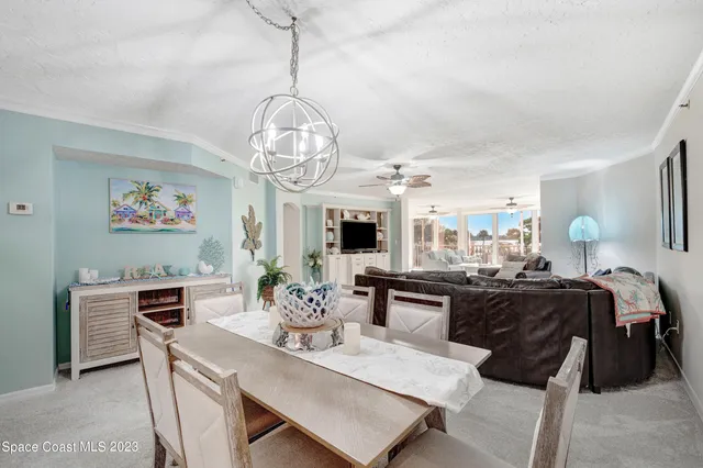 a view of a dining room with furniture a chandelier and wooden floor