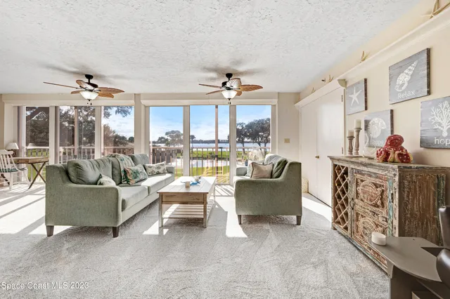 a living room with fireplace furniture and a large window