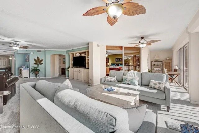 a living room with furniture kitchen view and a large window