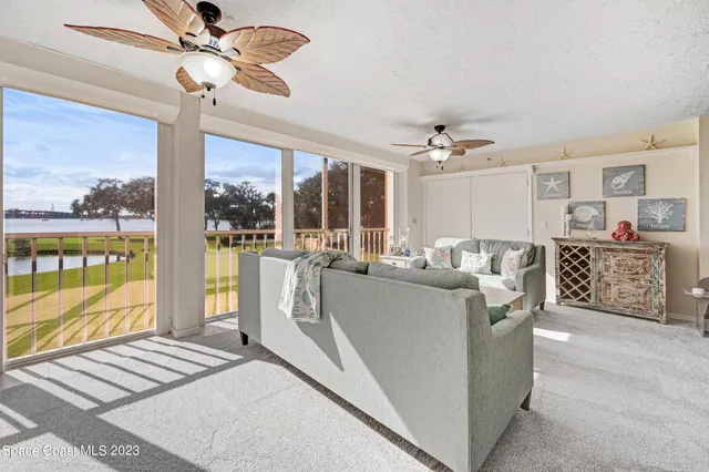 a living room with furniture and a floor to ceiling window