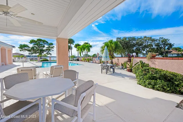 a view of a patio with a table and chairs under an umbrella