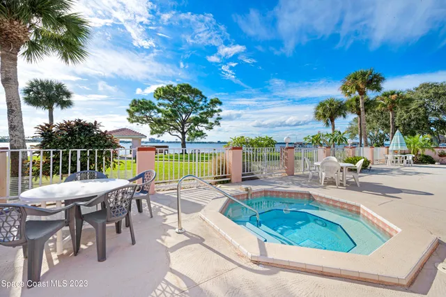 a view of a swimming pool with lawn chairs under an umbrella