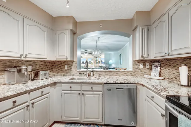 a kitchen with granite countertop a sink and cabinets