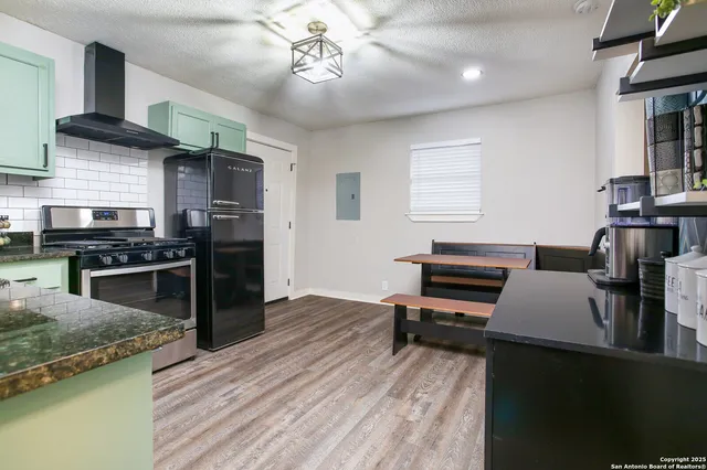 a kitchen with stainless steel appliances granite countertop a stove and a refrigerator