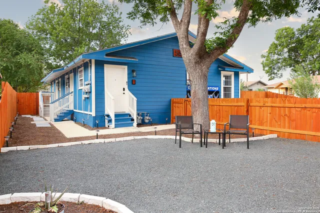 a view of a house with backyard and a tree