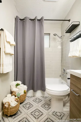 a bathroom with a toilet sink and shower curtain
