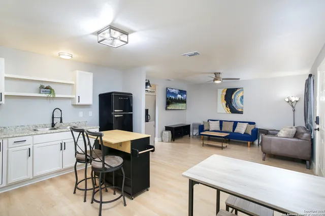 a living room with furniture a rug and a ceiling fan