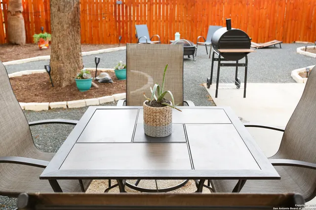 a view of a house with backyard water fountain and sitting area