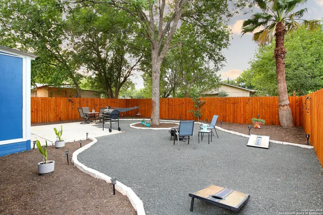 a backyard of a house with garden and outdoor seating