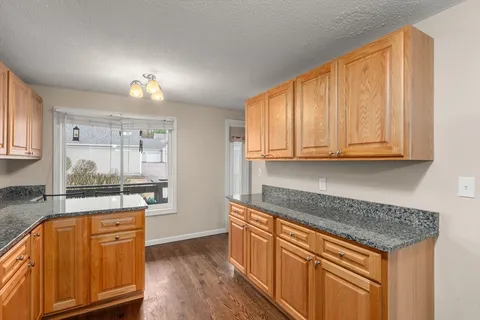 a kitchen with stainless steel appliances granite countertop wooden cabinets and a counter top space