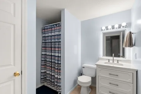 a bathroom with a granite countertop sink toilet and shower