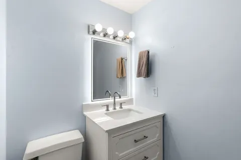 a bathroom with a sink vanity and toilet