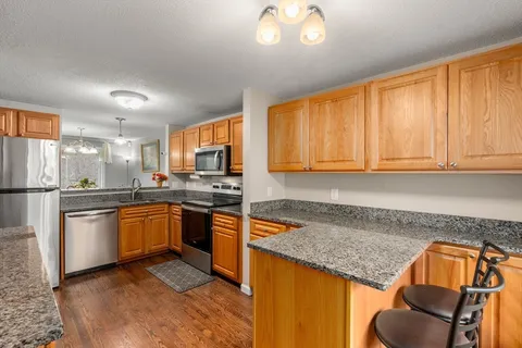 a kitchen with stainless steel appliances granite countertop sink stove top oven and cabinets