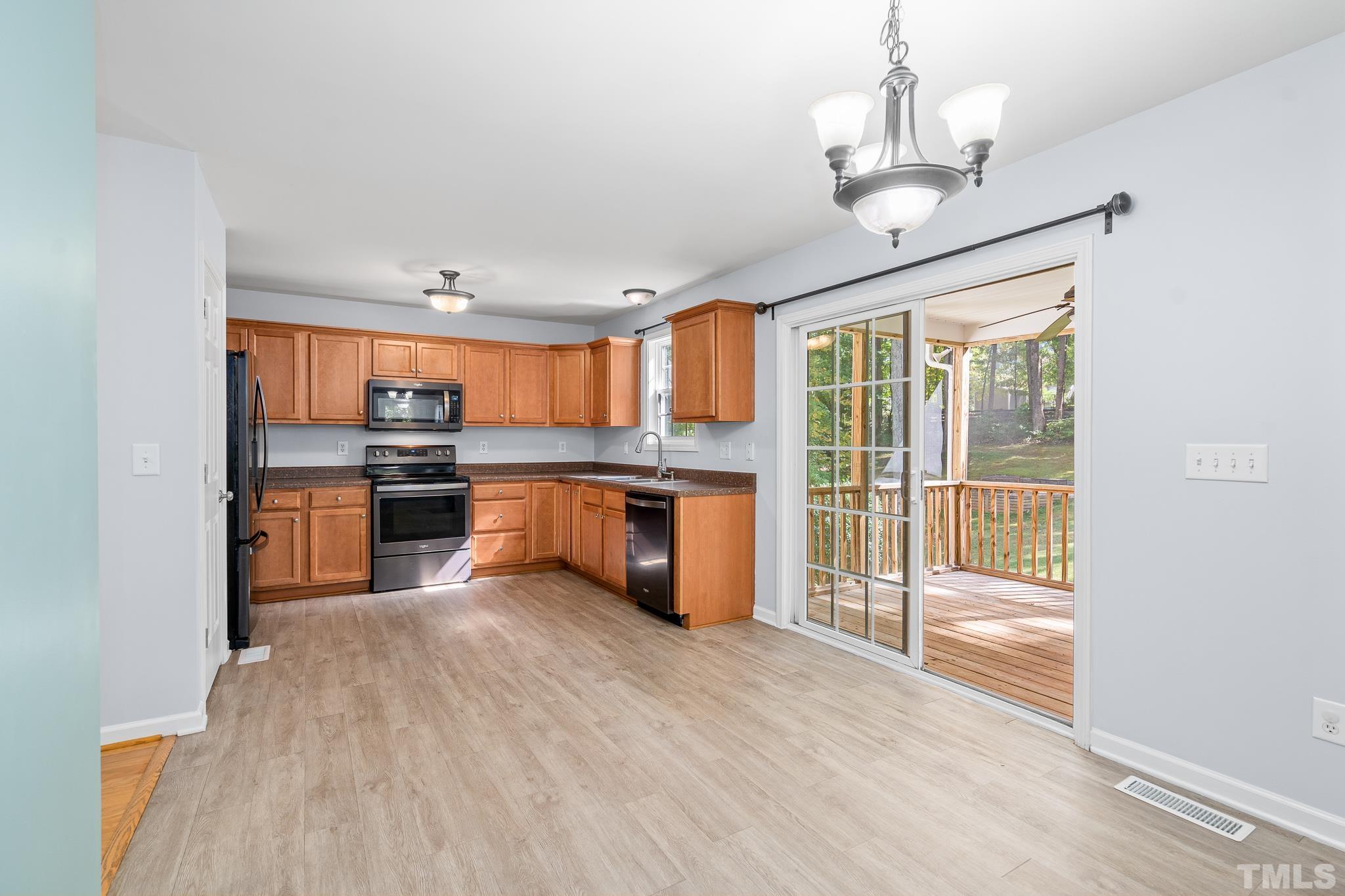 130 Broken Lance Drive Youngsville, NC 27596 - Photo 15 of 32 a open kitchen with stainless steel appliances granite countertop a stove oven and a refrigerator with wooden floor