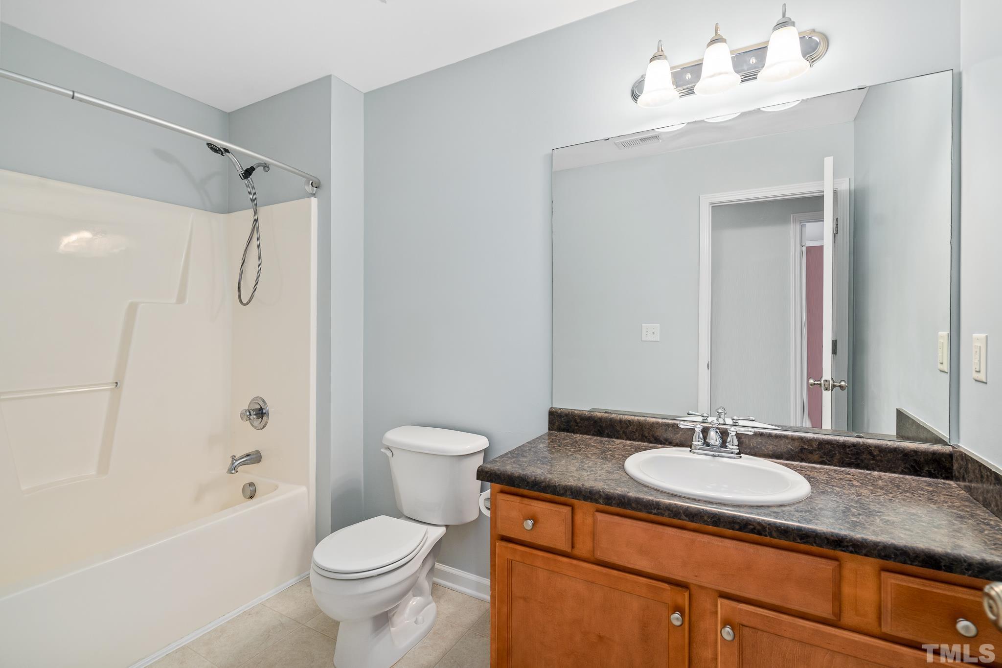 130 Broken Lance Drive Youngsville, NC 27596 - Photo 23 of 32 a bathroom with a granite countertop sink toilet and shower