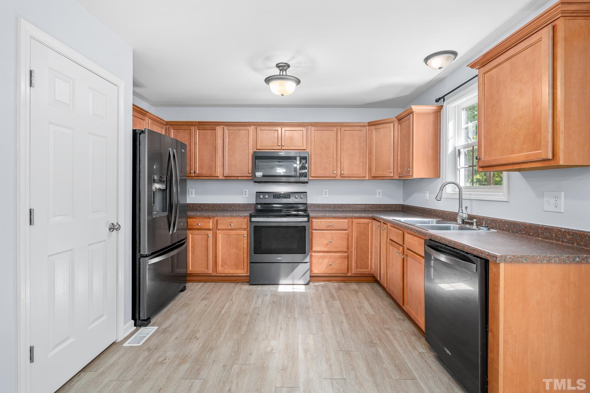 130 Broken Lance Drive Youngsville, NC 27596 - Photo 9 of 32 a kitchen with granite countertop stainless steel appliances and wooden cabinets