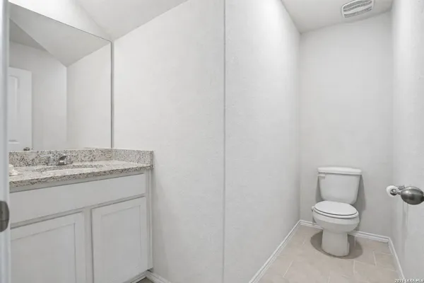 a bathroom with a granite countertop toilet and sink