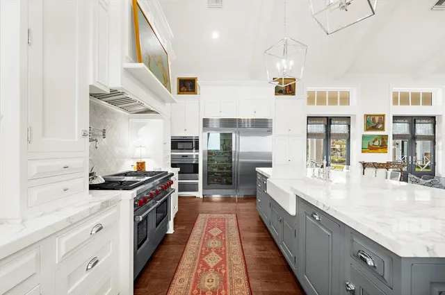 a large white room with a large window and a kitchen view
