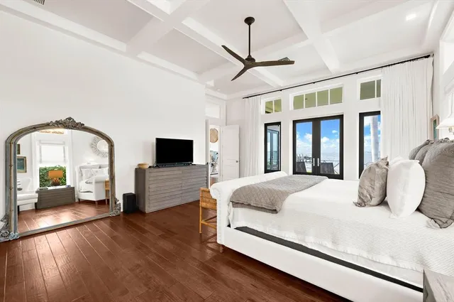 a bedroom with bed and a flat tv screen on dresser