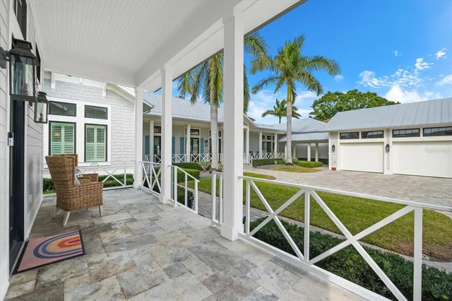 a front view of a house with a large window and potted plants
