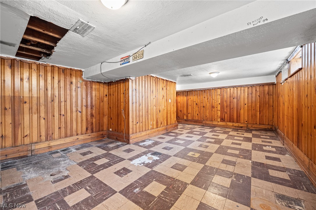 3799 Colony Road South Euclid, OH 44118 - Photo 26 of 34 Basement featuring a textured ceiling and wooden walls