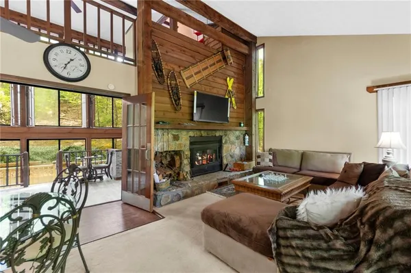 a living room with furniture a fireplace and a floor to ceiling window
