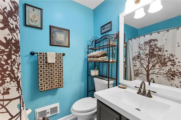 a bathroom with a granite countertop sink a toilet and shower