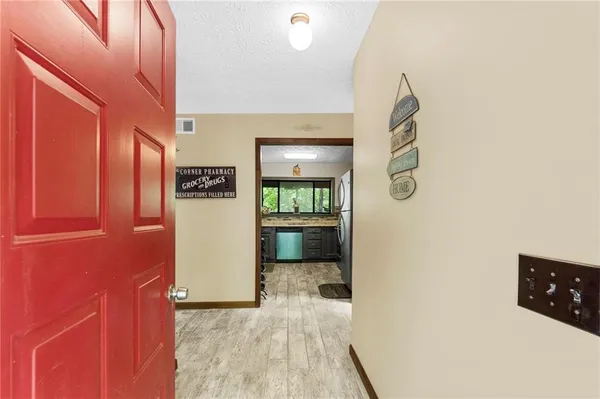 a view of a hallway with wooden floor and dining room
