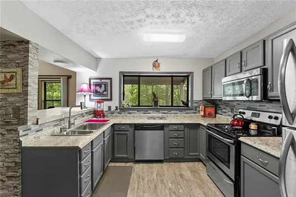 a kitchen with a sink stove a sink and dishwasher a oven with wooden cabinets
