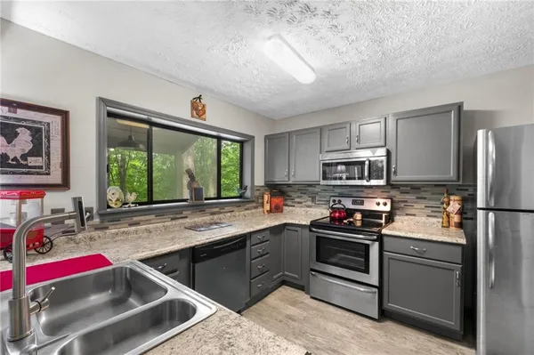 a kitchen that has a sink stove and a refrigerator