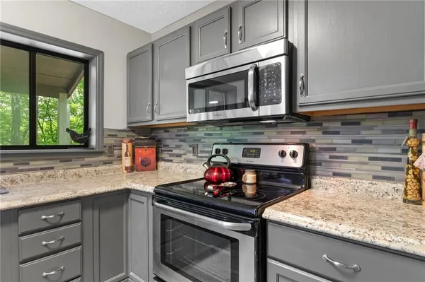a kitchen with stainless steel appliances granite countertop a sink stove and microwave