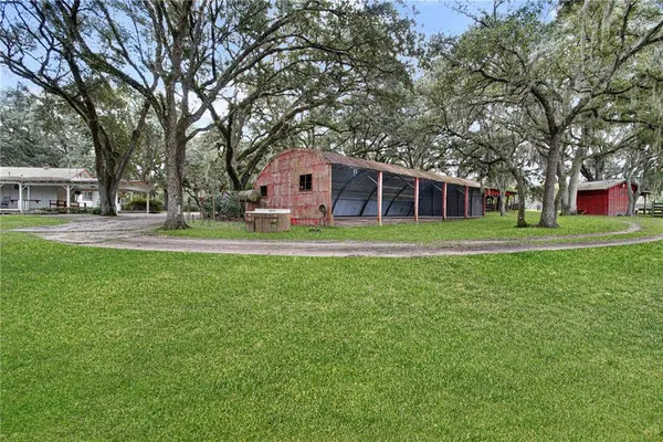 a front view of a house with a yard and trees