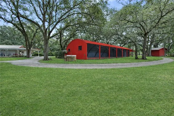 a view of a back yard with green space and bench