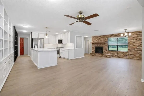 a view of a kitchen with a sink a refrigerator and window