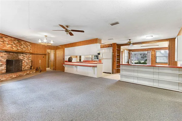 a living room with stainless steel appliances furniture and a fireplace