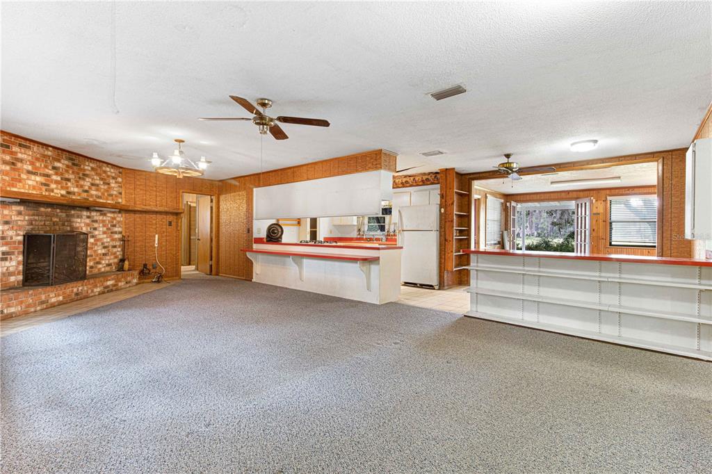 3350 Northeast 125th Terrace Road Silver Springs, FL 34488 - Photo 30 of 47 a living room with stainless steel appliances furniture and a fireplace