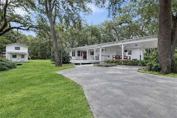 a front view of a house with a yard and trees