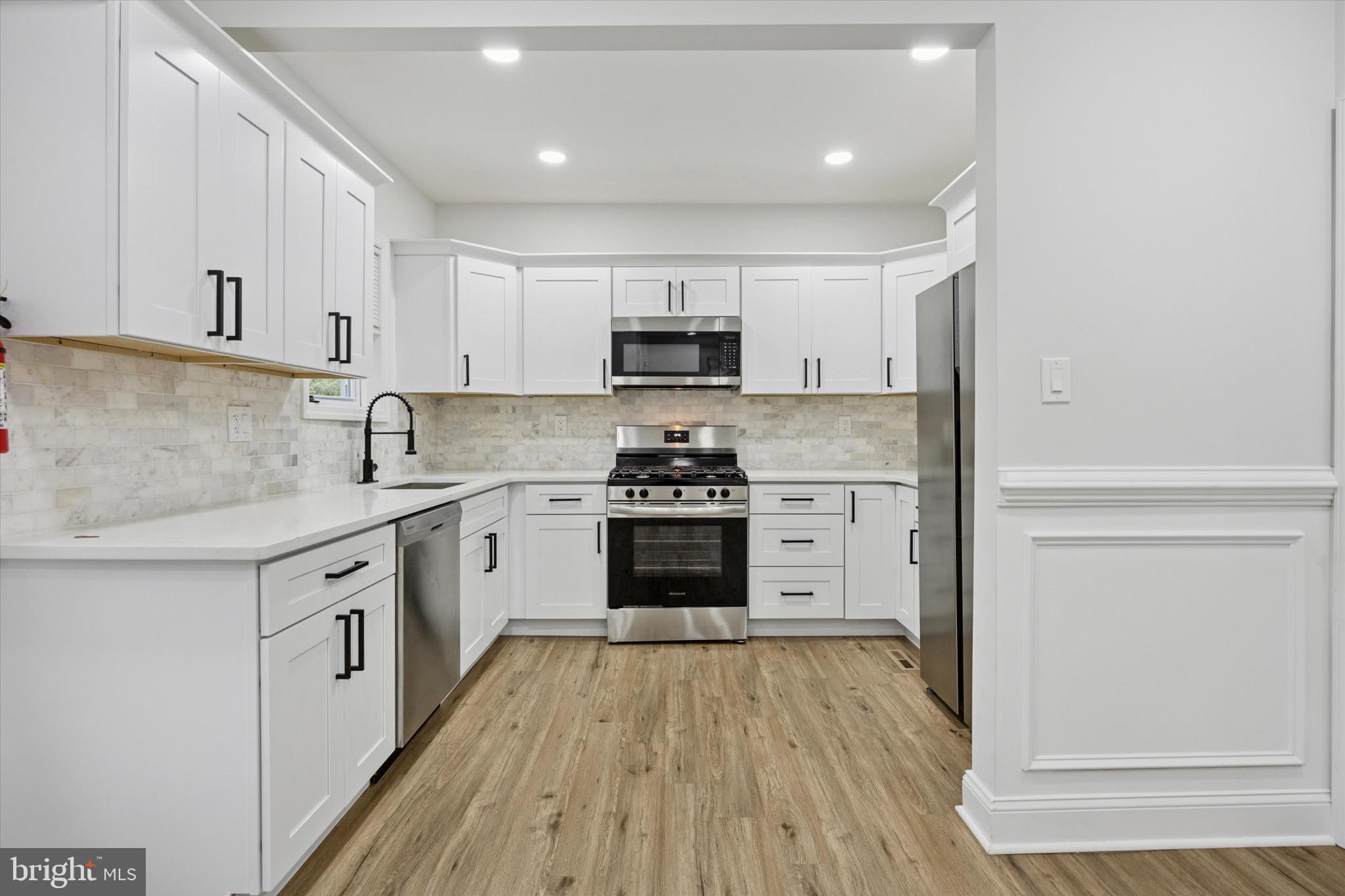 229 New Jersey Avenue, Unit B Collingswood, NJ 08108 - Photo 5 of 18 a kitchen with granite countertop a stove top oven sink and cabinets