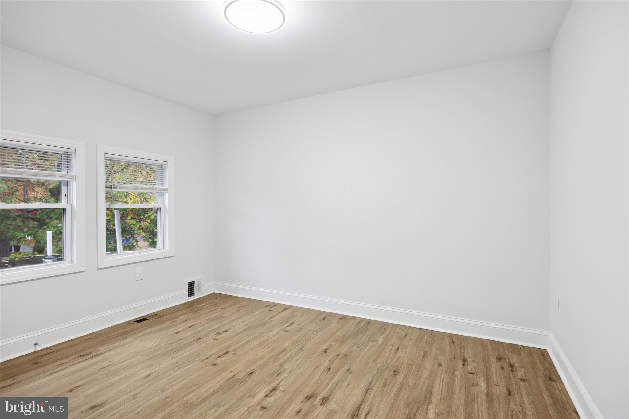 229 New Jersey Avenue, Unit B Collingswood, NJ 08108 - Photo 7 of 18 an empty room with wooden floor and windows