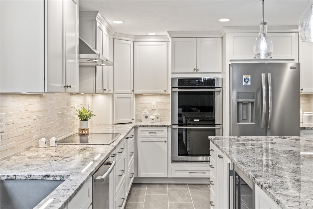 5 Strawberry Lane Norfolk, MA 02056 - Photo 5 of 42 a kitchen with stainless steel appliances granite countertop a kitchen island a stove a refrigerator and a sink
