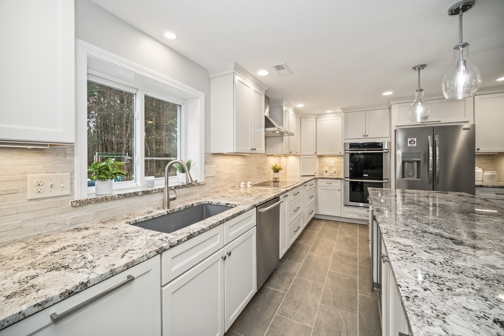 5 Strawberry Lane Norfolk, MA 02056 - Photo 6 of 42 a large kitchen with granite countertop a large counter top a sink stainless steel appliances and cabinets