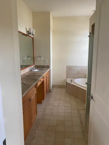 a bathroom with a granite countertop sink and a mirror